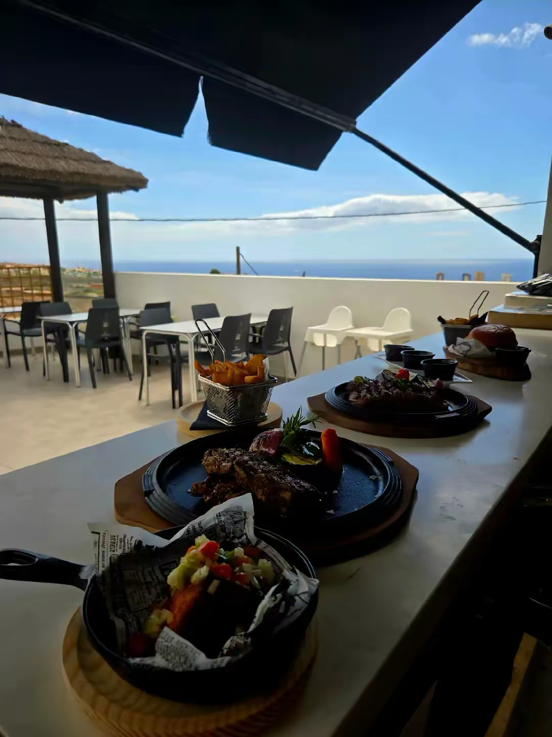 Glass of local Tenerife red wine paired with a juicy steak on an ocean view terrace
